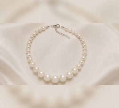 White pearl necklace on satin background