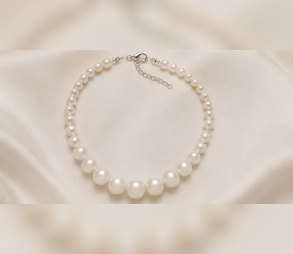 White pearl necklace on satin background