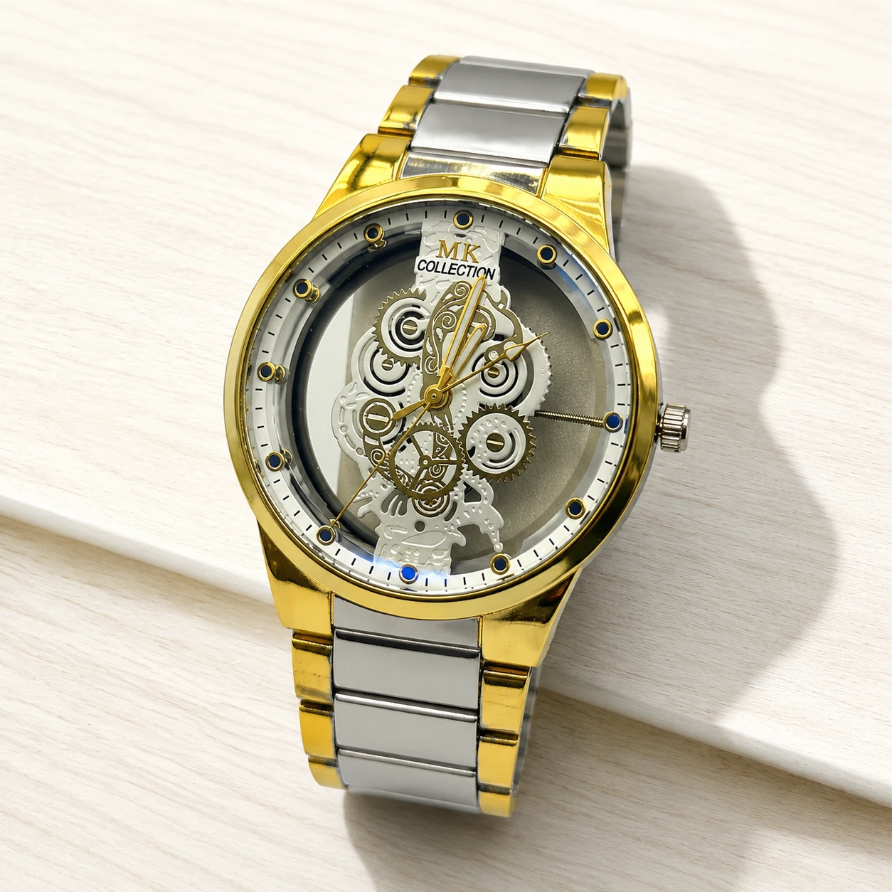 Gold and silver skeleton watch with intricate mechanical gears and metal bracelet