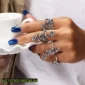 Ornate silver floral rings worn on a hand with blue nail polish