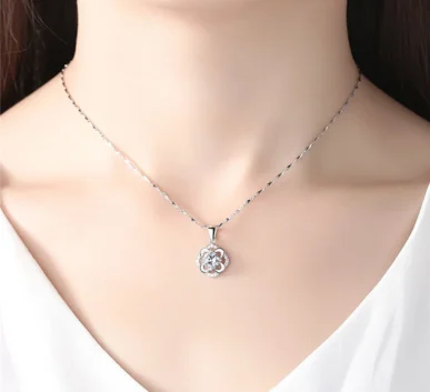 Elegant silver flower pendant necklace worn on a model