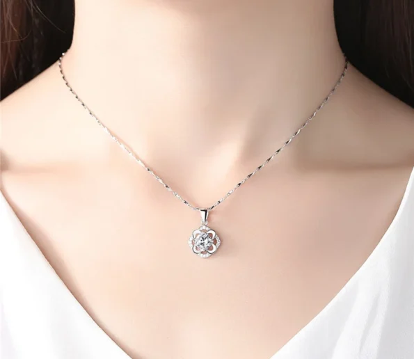 Elegant silver flower pendant necklace worn on a model