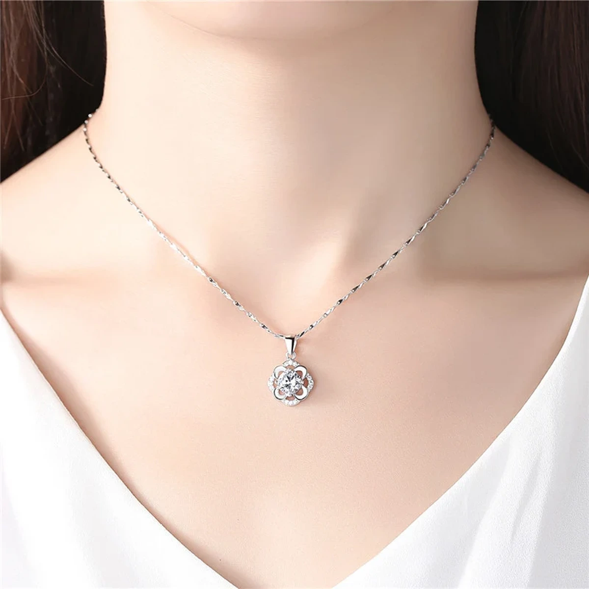 Elegant silver flower pendant necklace worn on a model