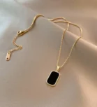 Gold chain necklace with black rectangular pendant