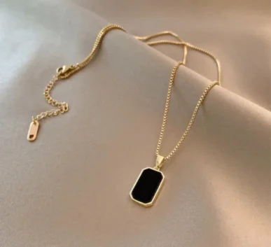 Gold chain necklace with black rectangular pendant