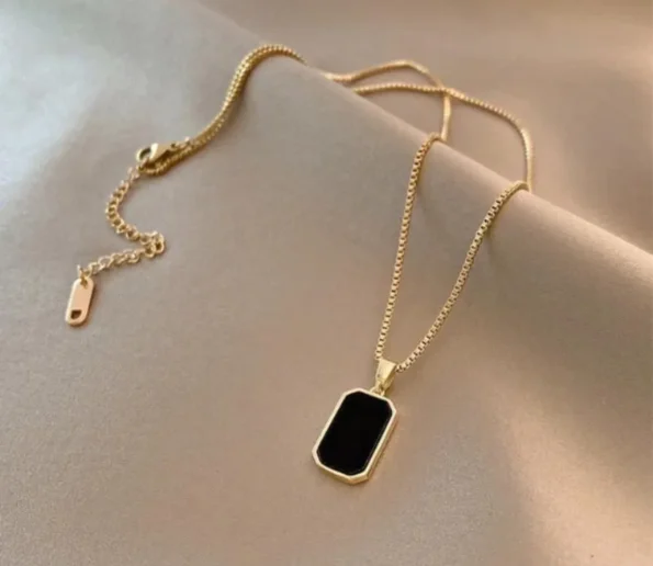 Gold chain necklace with black rectangular pendant