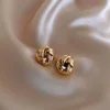 Elegant gold knot earrings on soft beige fabric