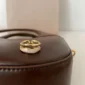 Elegant gold open ring displayed on a brown leather surface