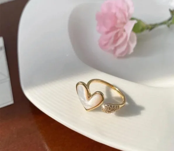 Elegant gold heart-shaped ring displayed on a white plate