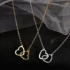 Gold and silver heart-shaped necklaces displayed on black fabric