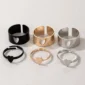Collection of black, gold, and silver heart rings on a light background