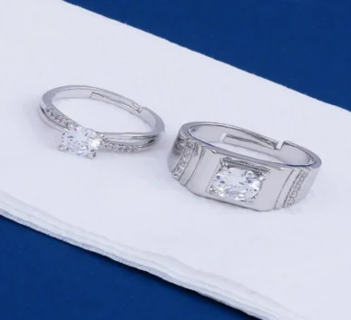 Elegant silver diamond rings with sparkling stones on a white surface