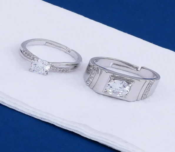 Elegant silver diamond rings with sparkling stones on a white surface