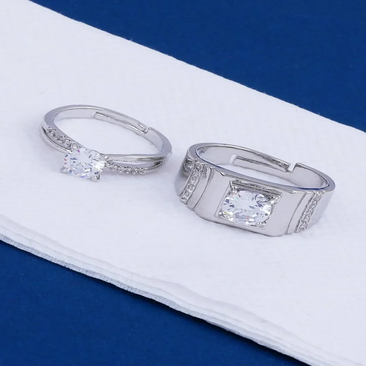 Elegant silver diamond rings with sparkling stones on a white surface