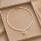 Elegant white pearl necklace with gold bow pendant
