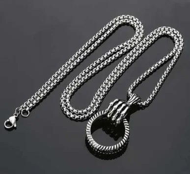 Silver chain necklace with a round pendant on a dark background