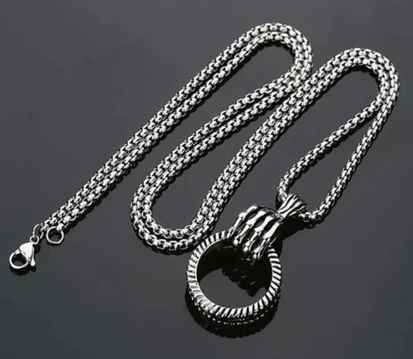 Silver chain necklace with a round pendant on a dark background