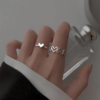 Silver heart and love-themed rings worn on a hand