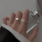 Silver heart and love-themed rings worn on a hand