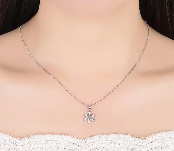 Elegant silver snowflake pendant necklace on a model