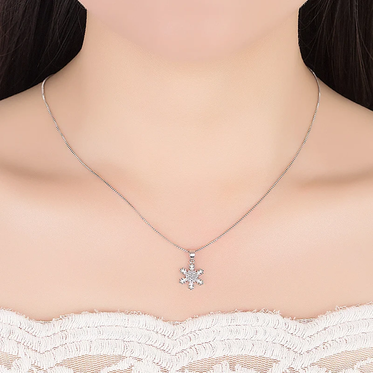 Elegant silver snowflake pendant necklace on a model