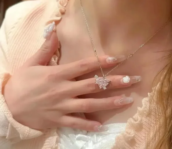 Sparkling silver pendant necklace worn against a white outfit