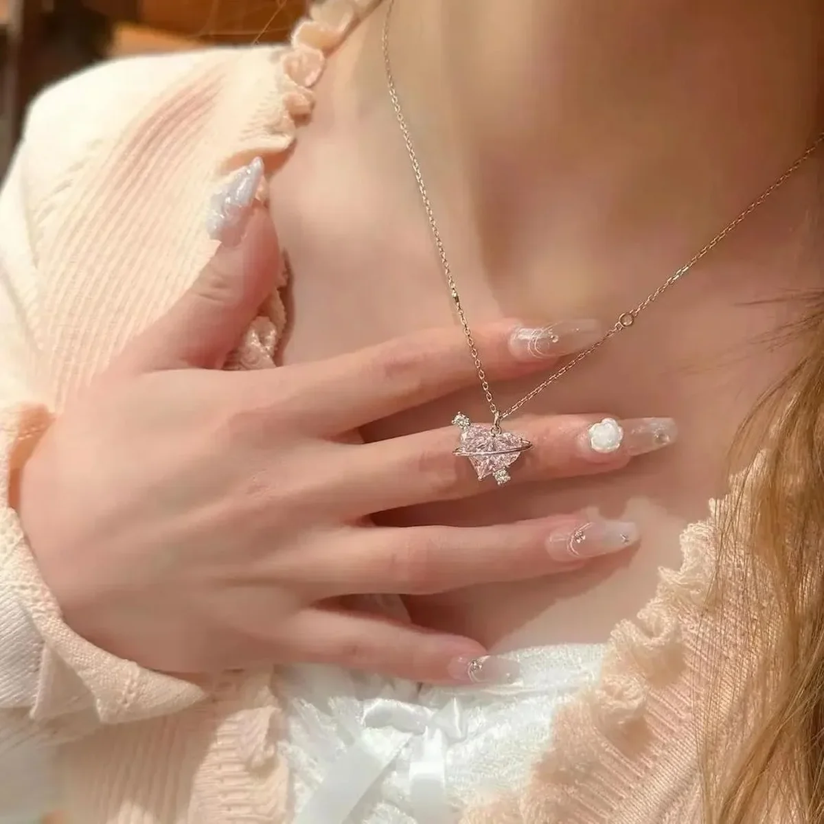 Sparkling silver pendant necklace worn against a white outfit