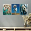 Three abstract white horse paintings in teal, blue, and gold tones displayed above a wooden console table with dried floral arrangements