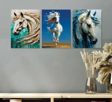 Three abstract white horse paintings in teal, blue, and gold tones displayed above a wooden console table with dried floral arrangements
