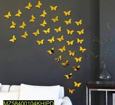 Yellow butterfly wall stickers arranged in a flying pattern on a dark gray wall above a white sofa.