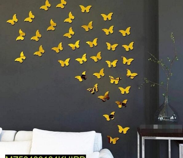 Yellow butterfly wall stickers arranged in a flying pattern on a dark gray wall above a white sofa.