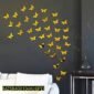 Yellow butterfly wall stickers arranged in a flying pattern on a dark gray wall above a white sofa.