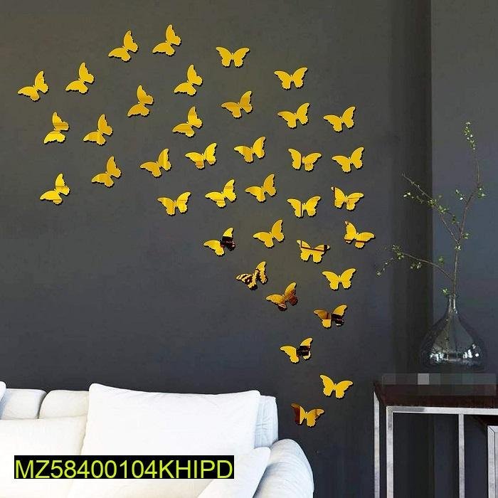 Yellow butterfly wall stickers arranged in a flying pattern on a dark gray wall above a white sofa.