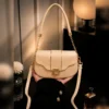 Beige women’s shoulder bag with gold chain and long strap