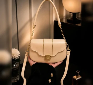 Beige women’s shoulder bag with gold chain and long strap