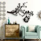 Black tree branch wall decor with birds and hanging birdcage in a modern living room
