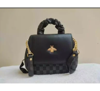 Black handbag with gold chain strap and bee-shaped decorative emblem