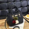 Black structured women’s handbag with gold-tone hardware, top handles