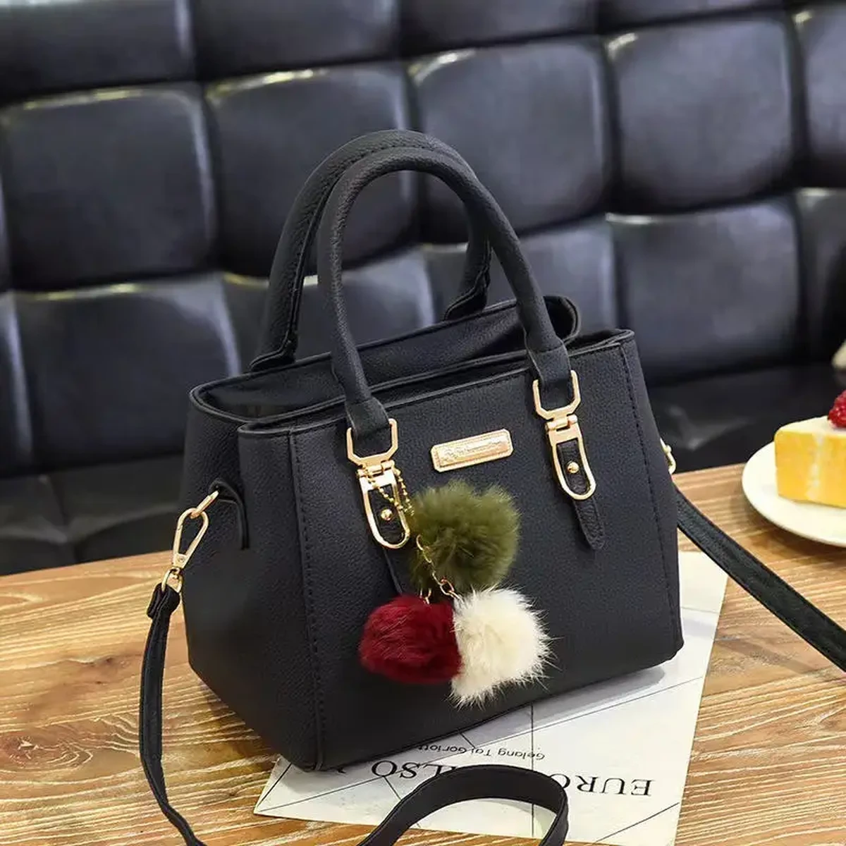 Black structured women’s handbag with gold-tone hardware, top handles