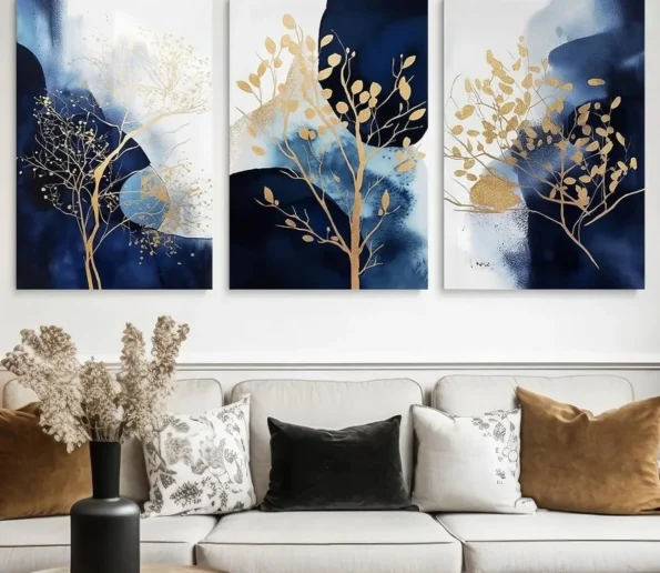 Blue and gold three-panel tree wall art above a modern living room sofa