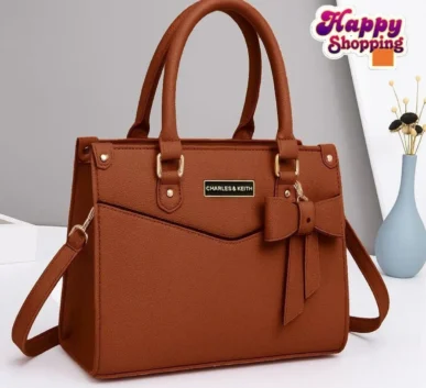 Brown women’s handbag with bow detail and shoulder strap