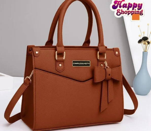 Brown women’s handbag with bow detail and shoulder strap