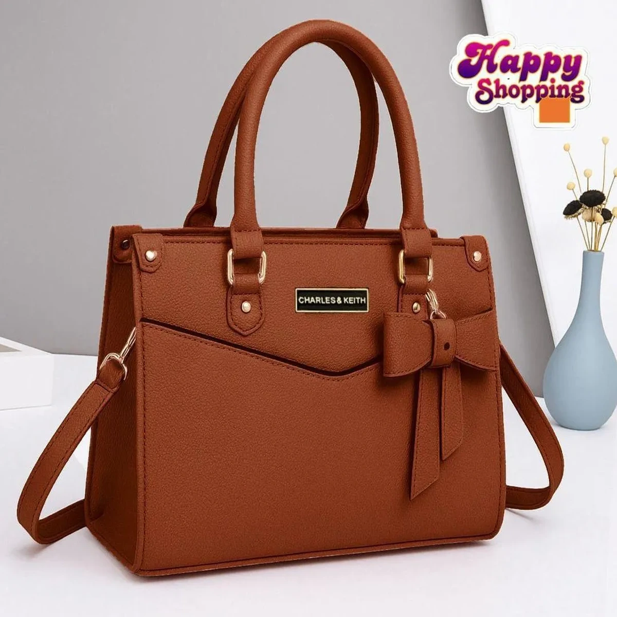 Brown women’s handbag with bow detail and shoulder strap