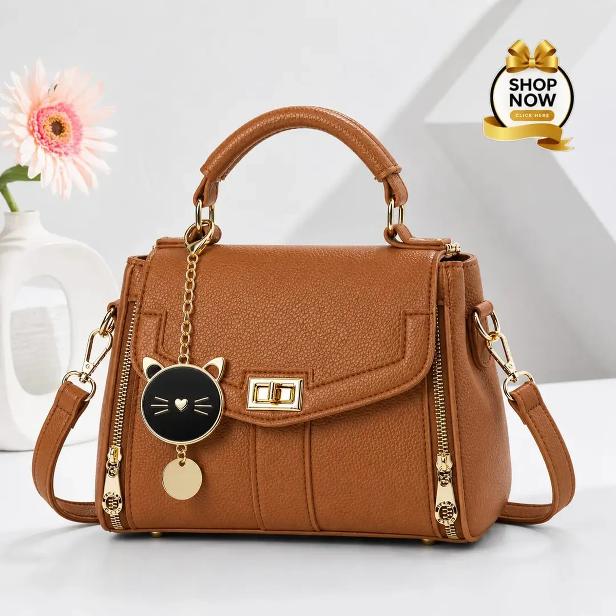 Brown women’s handbag with gold details and cat charm