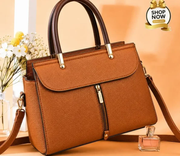 Elegant brown women’s handbag with top handles, front zipper, and shoulder strap.