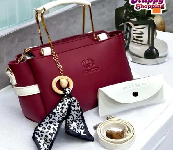 Burgundy women’s handbag with white handles and decorative charm