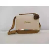 Cream and brown crossbody handbag with top handle and decorative pom pom