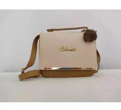 Cream and brown crossbody handbag with top handle and decorative pom pom
