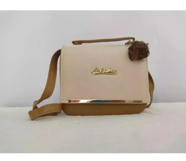 Cream and brown crossbody handbag with top handle and decorative pom pom