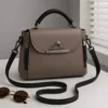 Taupe women’s handbag with black top handle and adjustable shoulder strap